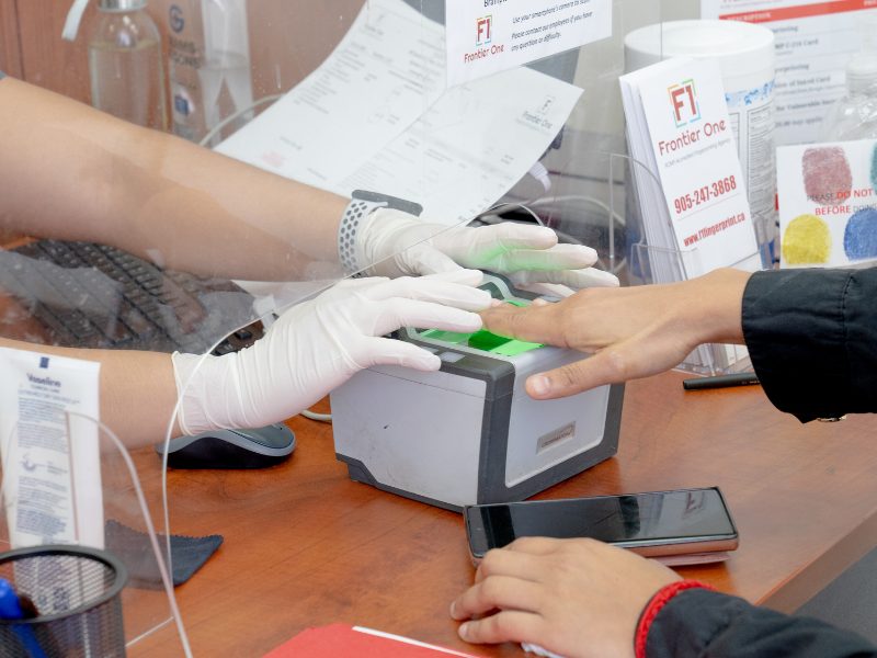 Brampton office: fingerprints being taken on a digital Live Scan device