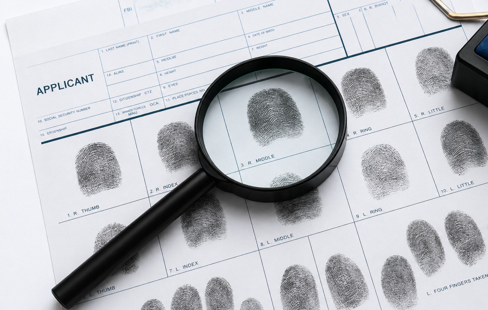 A magnifying glass over a fingerprint card.
